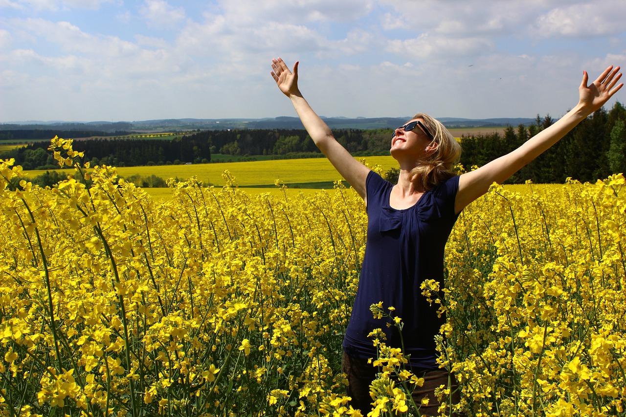 Woman expressing gratitude in field of flowers